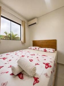 a bedroom with a bed with red flowers on it at Pousada São José in Joinville