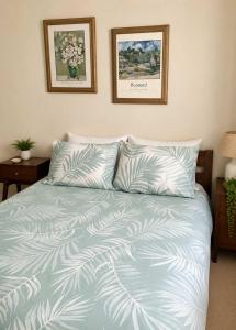 a bedroom with a bed with a blue comforter at Seascape Carroll Avenue - close to Mollymook Beach in Mollymook
