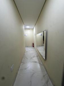 a hallway with a mirror on a wall at Oeste Palace-hotel londres in Brasília