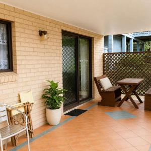 a patio with a table and a chair and a table at Seascape Carroll Avenue - close to Mollymook Beach in Mollymook