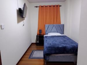 a bedroom with a bed with a blue comforter at Casa Sajama 121 in La Paz