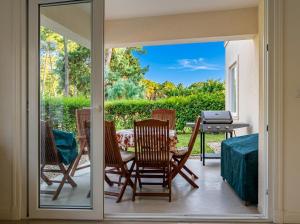 a room with a patio with chairs and a table at Green Park Departamentos Exclusivos in Punta del Este