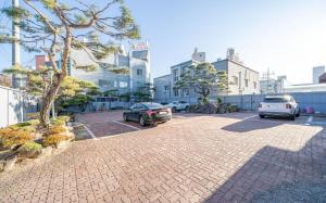 a parking lot with two cars parked in it at Andong Win Hotel in Hoam-dong
