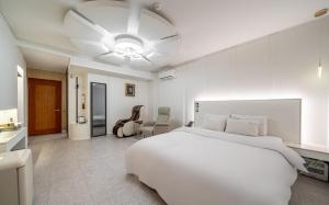 a bedroom with a white bed and a ceiling fan at Andong Win Hotel in Hoam-dong