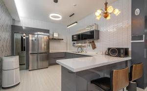 a large kitchen with a large counter and a refrigerator at Andong Win Hotel in Hoam-dong