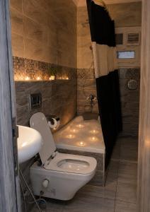 a bathroom with a toilet and a sink and a tub at Pyramids Gardens 2bedroom apartment in ‘Ezbet `Abd el-Ḥamîd