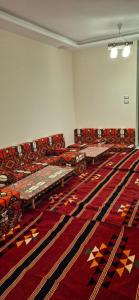 an empty room with tables and chairs on a rug at Pyramids Gardens 2bedroom apartment in ‘Ezbet `Abd el-Ḥamîd
