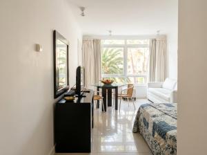 a bedroom with a bed and a desk with a television at Green Park Departamentos Exclusivos in Punta del Este
