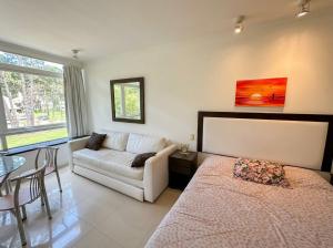 a living room with a bed and a couch at Green Park Departamentos Exclusivos in Punta del Este +128 photos