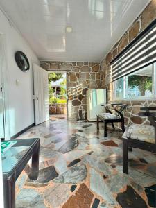 a living room with a stone wall and a table at Cabañas El Itali in Fusagasuga