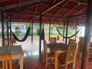 a wooden table and chairs under a tent at hostal EMBAMAR in Palomino