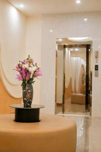 a vase with flowers sitting on a table in a lobby at TherHouse in Mộc Châu