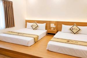 two beds in a hotel room with white walls at TherHouse in Mộc Châu