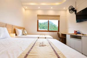 a hotel room with two beds and a window at TherHouse in Mộc Châu +61 photos