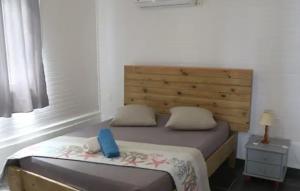 a bedroom with a bed with a wooden headboard at Case du pêcheur in Grand-Bourg