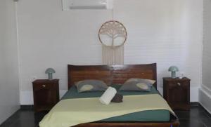 a bedroom with a large bed with two night stands at Case du pêcheur in Grand-Bourg