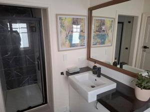 a bathroom with a sink and a shower and a mirror at Private sanctuary between river and sea in Perth