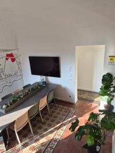 a living room with a table and chairs and a flat screen tv at Liotru Maisonne, rooms with en-suite bathroom and shared bathroom in Catania