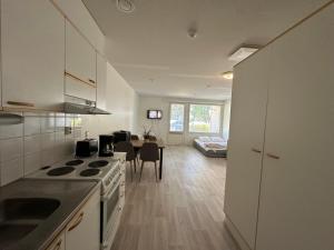 a kitchen with a stove and a dining room at Mysig Lägenhet in Kokkola