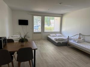 a living room with two beds and a table at Mysig Lägenhet in Kokkola