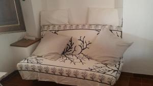 a small bed with white sheets and pillows at I Dammusi di Pippo in Lampedusa