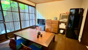 a living room with a table and a refrigerator at Kyoto Gion No Yado in Kyoto