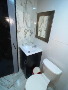 a bathroom with a white toilet and a sink at Mini Loft en Quezaltepeque in Quezaltepeque +2 photos