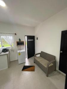 a living room with a couch and a tv and a kitchen at Departamento al lado del Mar in Barra Nueva