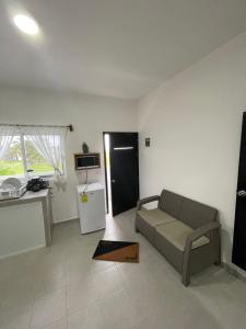 a living room with a couch and a kitchen at Departamento al lado del Mar in Barra Nueva