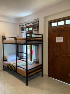 two bunk beds in a room with a door at Noname Hostel ella in Ella +69 photos