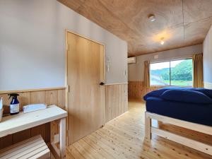 ein kleines Zimmer mit einem Bett und einem Fenster in der Unterkunft michikusha in Maniwa
