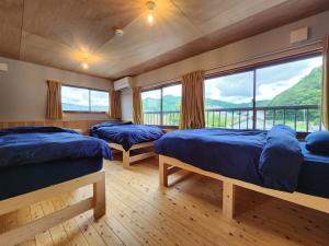 ein Schlafzimmer mit zwei Betten und einem großen Fenster in der Unterkunft michikusha in Maniwa