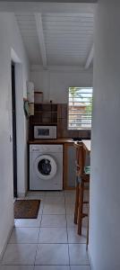 a kitchen with a washing machine and a window at 36 Baltazia, 2 Ch 2 Pers-Clim jardin terrasse à Sainte-Anne in Sainte-Anne