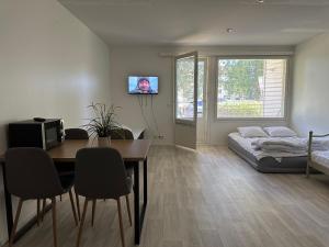 a living room with a table and a bed at Mysig Lägenhet in Kokkola