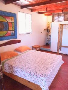 a bedroom with a bed and a painting on the wall at Hostel La Ballena Backpacker in Las Galeras