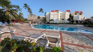 a resort swimming pool with chairs and condos at my house on the upper beach in Villas del Mar +8 photos