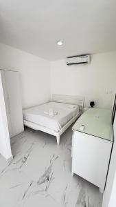 a white room with a bed and a table at my house on the upper beach in Villas del Mar