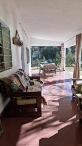 a living room with a couch and a patio at Casa con bajada al rio in Villa Cura Brochero