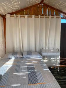 a bedroom with a bed and a desk in a tent at La Bahia de Makale in Pisco