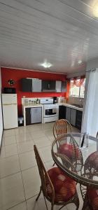 a kitchen with a table and chairs and a kitchen with red walls at Costa Rica explorer in Grecia +53 photos