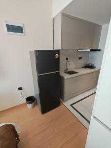 a kitchen with a black refrigerator and a sink at 城绩公寓 in Phnom Penh