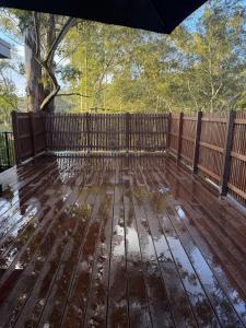 an umbrella on a wooden deck with a fence at Gosford Retreat in Gosford
