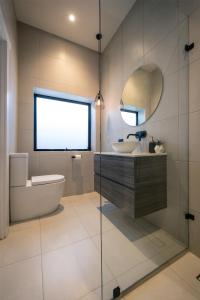 a bathroom with a tub and a sink and a mirror at Gosford Retreat in Gosford