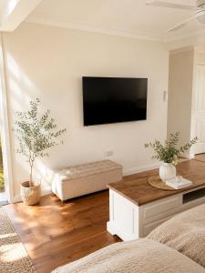 a living room with a flat screen tv on the wall at Gosford Retreat in Gosford