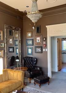 a living room with a couch and a chair and a mirror at Central Blenheim Villa in Blenheim