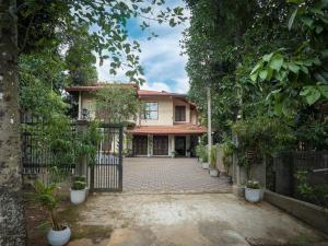 an entrance to a house with a gate and trees at Kandy 888 Villa in Kandy