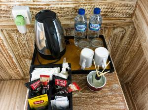 a table with a coffee maker and two bottles of water at Villa Wakem Yehpoh in Yehpoh