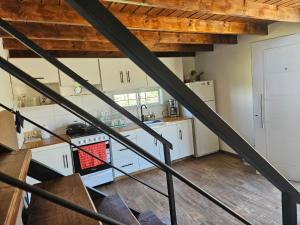 a kitchen with white cabinets and wooden ceilings at Vertiente escondida in Villa Yacanto