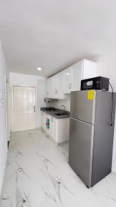 a kitchen with white cabinets and a stainless steel refrigerator at my house on the upper beach in Villas del Mar
