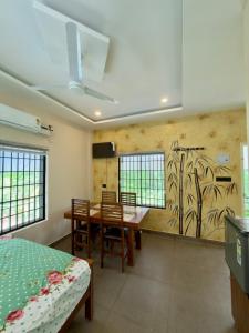 a dining room with a table and a painting on the wall at Fruits Garden Resort in Kotamangalam
